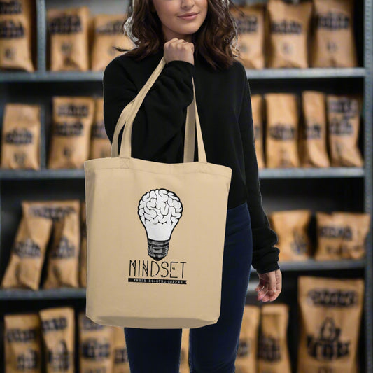 woman holding eco friendly bag with mindset coffee logo on it